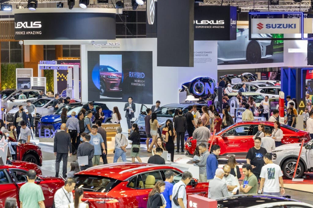 Crowded indoor exhibition hall at Singapore AutoExpo 2025 featuring car displays from Lexus, Suzuki, and other brands, highlighting the need for public events security.