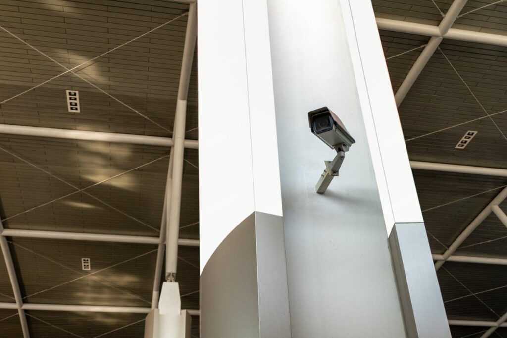 A modern security camera mounted on a column, providing remote CCTV monitoring for effective shoplifting prevention in a commercial space.