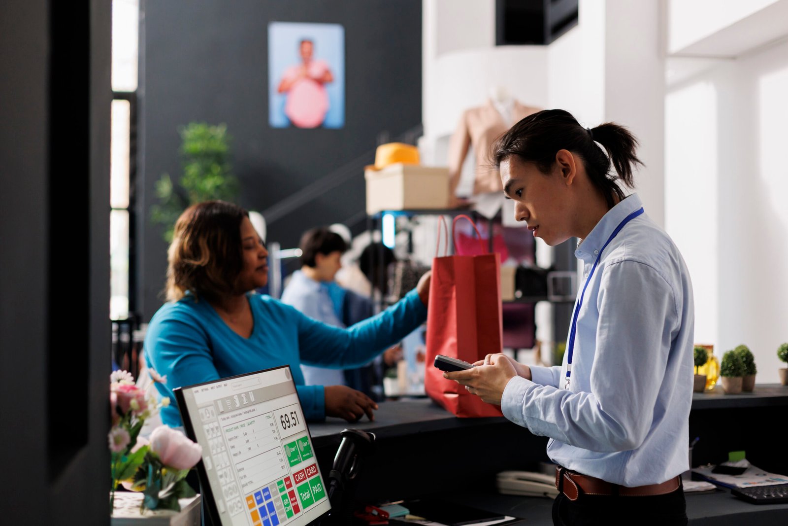 A cashier scans items for a customer at a retail counter, a scene protected by remote CCTV monitoring and small business surveillance packages