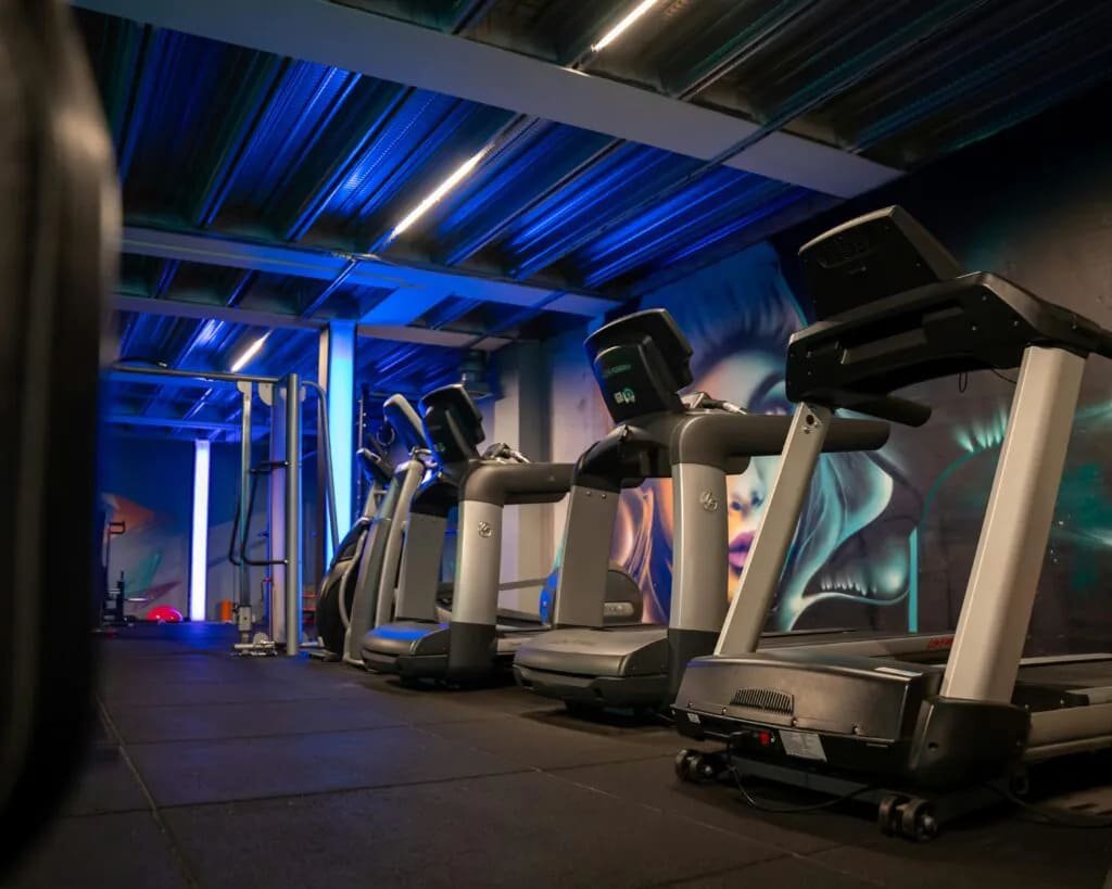 Modern, well-equipped gym with members working out under 24/7 CCTV surveillance.
