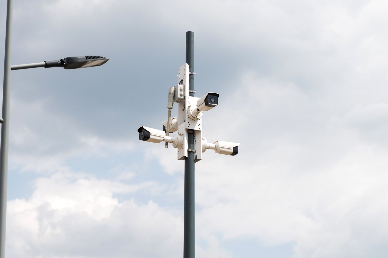 A tall metal pole featuring a cluster of white bullet-style cameras pointing in multiple directions, serving as an excellent visual example for anyone New to CCTV researching outdoor CCTV camera systems, surveillance camera networks, and CCTV security cameras for reliable residential surveillance or commercial use.