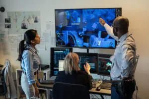 Team reviewing multiple CCTV feeds on a large screen in a control room, demonstrating advanced monitoring capabilities.