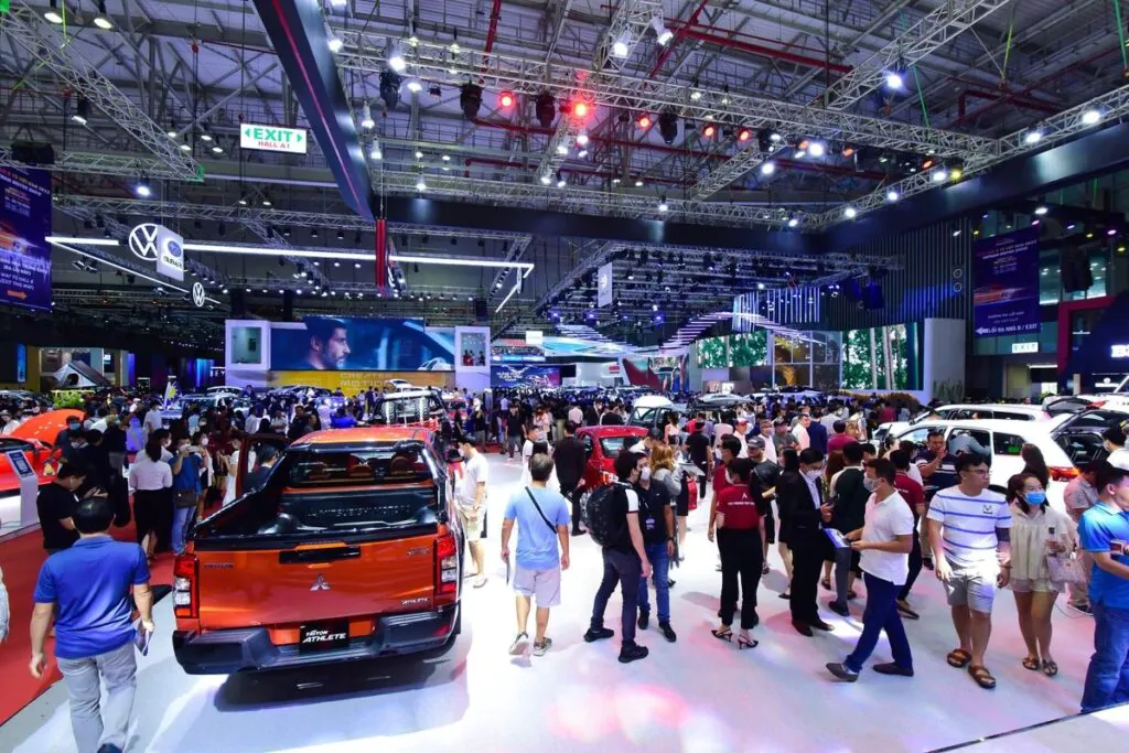 Wide-angle view of Singapore AutoExpo 2025 showing crowds walking through a massive exhibition hall with cars on display, emphasizing the need for public events security.
