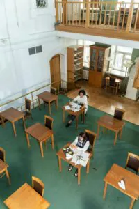 The main entrance of the University of [Name], a grand stone building with students walking by