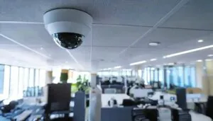 Dome security camera mounted on a ceiling in a modern office space, highlighting advanced CCTV monitoring technology. Modern office security camera providing continuous surveillance for business safety and compliance