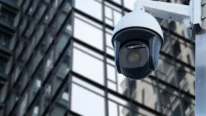 Outdoor PTZ security camera mounted on a building, providing 24/7 surveillance for business security.