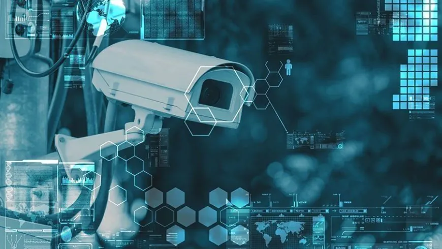Modern bullet-style security camera against a blue tech background with data graphs and network icons, symbolizing smart video monitoring services.