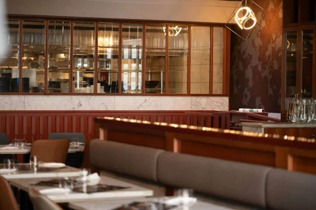 A security operator watching a multi-screen setup displaying live feeds, demonstrating active Screen Monitoring Services for restaurants and commercial businesses.