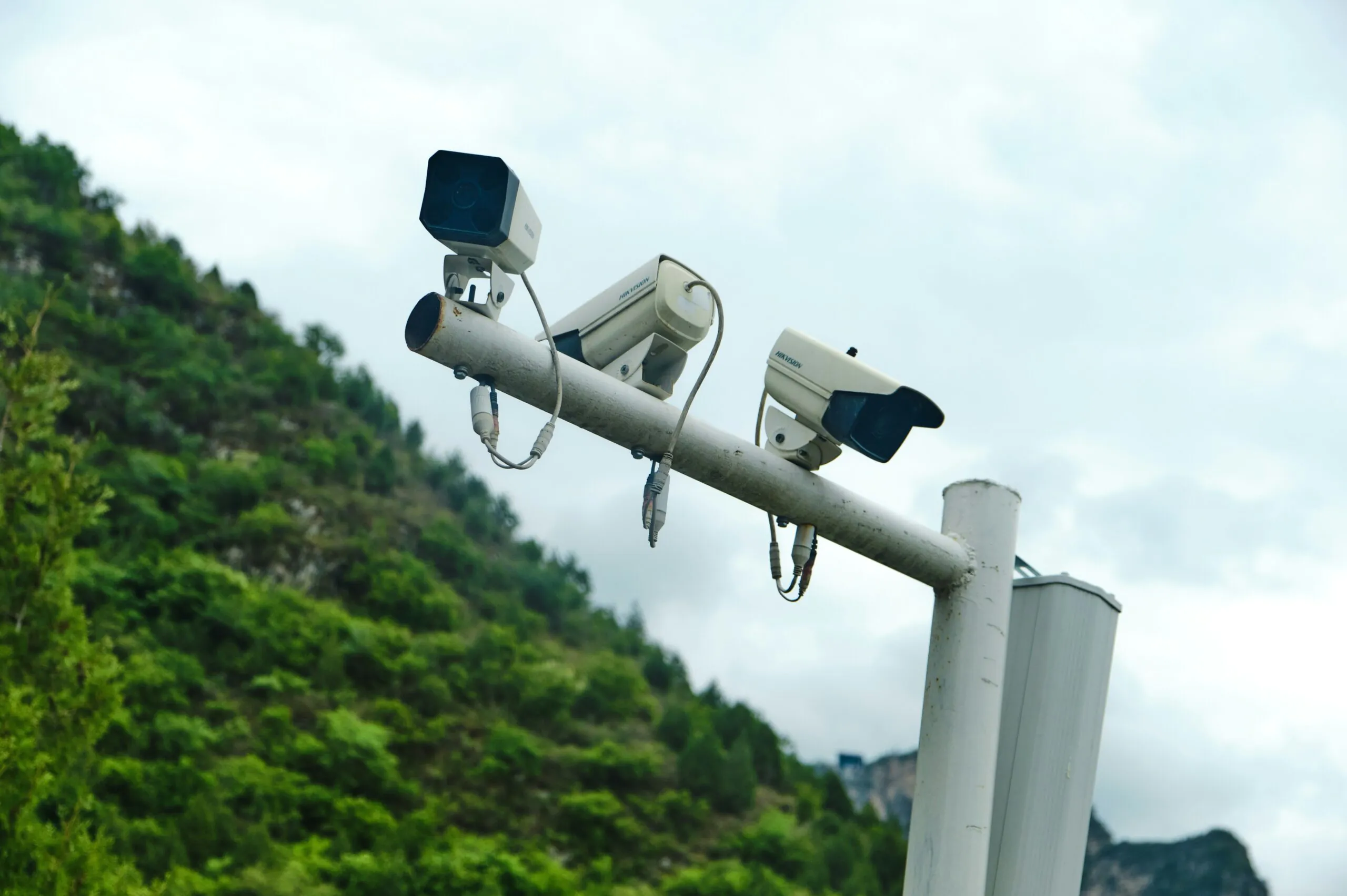 A collage of images showcasing end-to-end security, including outdoor dome cameras, indoor warehouse surveillance, multi-screen control rooms with male and female operators, access control systems, and two-way audio features, all unified by professional Remote cctv monitoring.