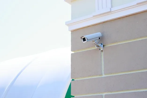 White bullet-style security camera mounted on a brick wall, symbolizing comprehensive Business Security solutions for UK businesses.