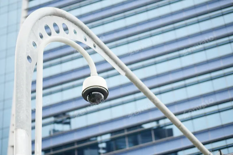A focused female security operator speaking into a two-way radio, with blurred monitor screens showing surveillance feeds in the background. This action illustrates the use of two-way audio surveillance.