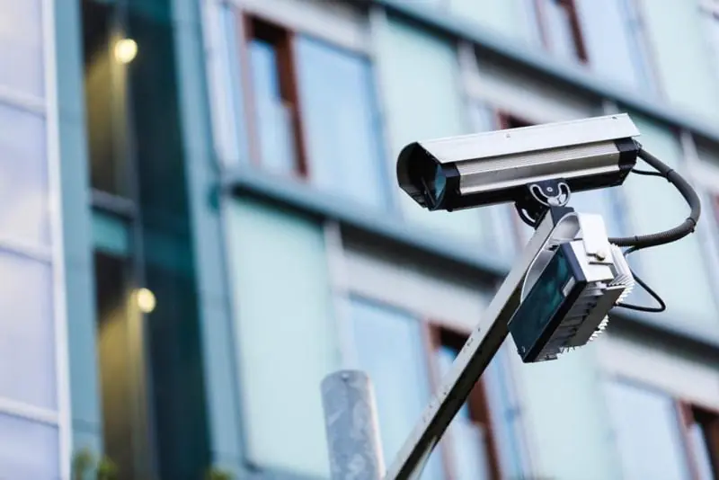 A security camera combined with a floodlight mounted on a pole, providing effective outdoor remote CCTV monitoring