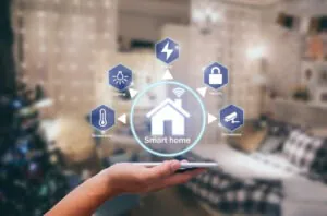 A person holding a smartphone displaying a smart home hub with icons for security, power, and lighting, highlighting the role of a professional CCTV Monitoring Provider in home security