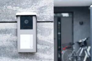 Alt Text: A sleek video intercom system mounted on a snow-dusted stone wall, representing the modern approach to Building Security and advanced Access Control through a Virtual Doorman.